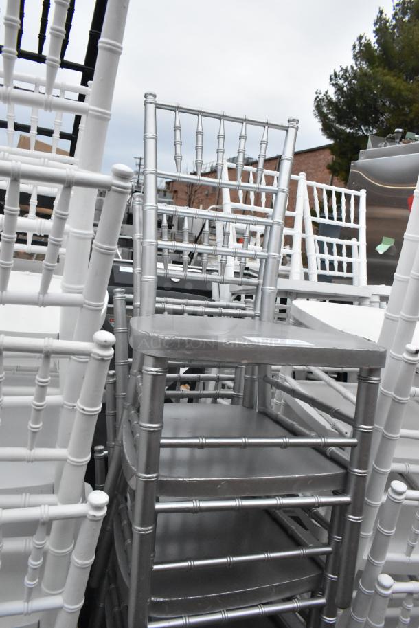 62 Chiavari stackable banquet chairs, various colors, durable construction, ideal for events. Some wear visible.
