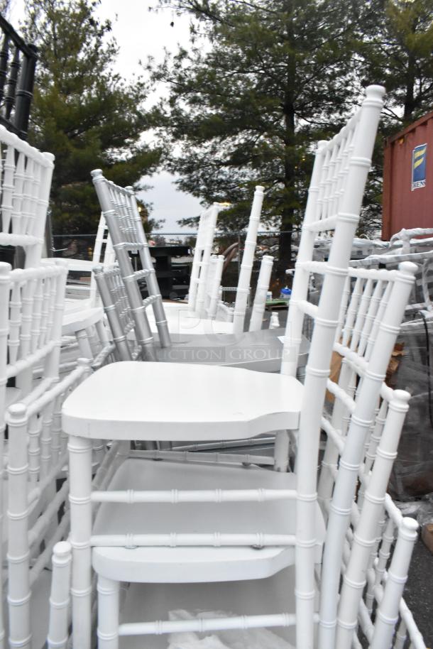 62 Chiavari stackable banquet chairs, white finish, various condition. Ideal for events. Includes 62 chairs per bid.