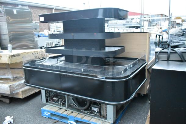 Black metal island-style Grab N Go merchandiser, multi-tiered design, freestanding, used condition, visible wiring underneath.