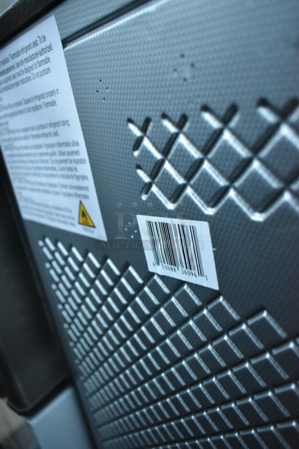 Barcoded metal panel on a mini cooler, textured surface with warning label. Part of a lot of six various mini coolers.