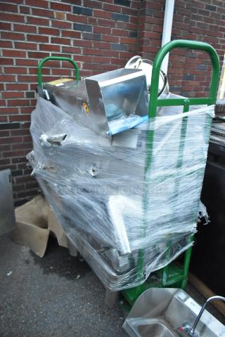 Metal green U-boat with wrapped contents, including a Shortening Shuttle and chafer, in used condition against a brick wall.