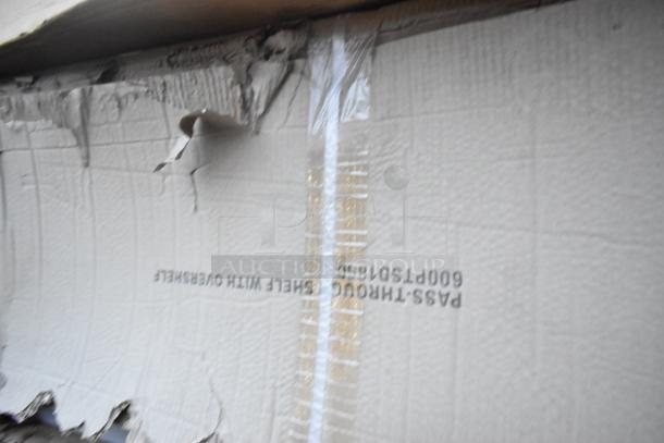 Damaged packaging of Regency stainless steel pass-through shelf, showing text "600PTSD1860." Item is new despite dents.