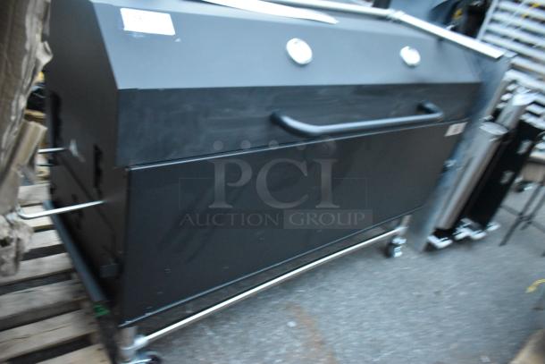 Backyard Pro black metal portable grill on commercial casters, featuring dual thermometers and side handles for easy mobility.