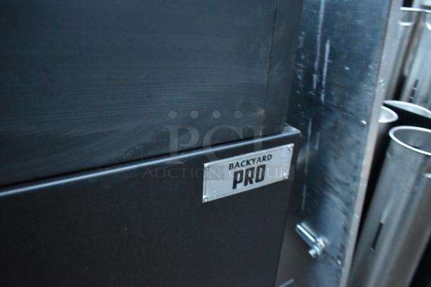 Backyard Pro black metal portable grill with a visible brand label. Features commercial casters for mobility.