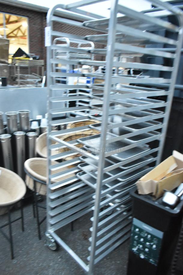 Metal portable pan rack with multiple shelves on commercial casters, used condition. Ideal for bakery or kitchen use.