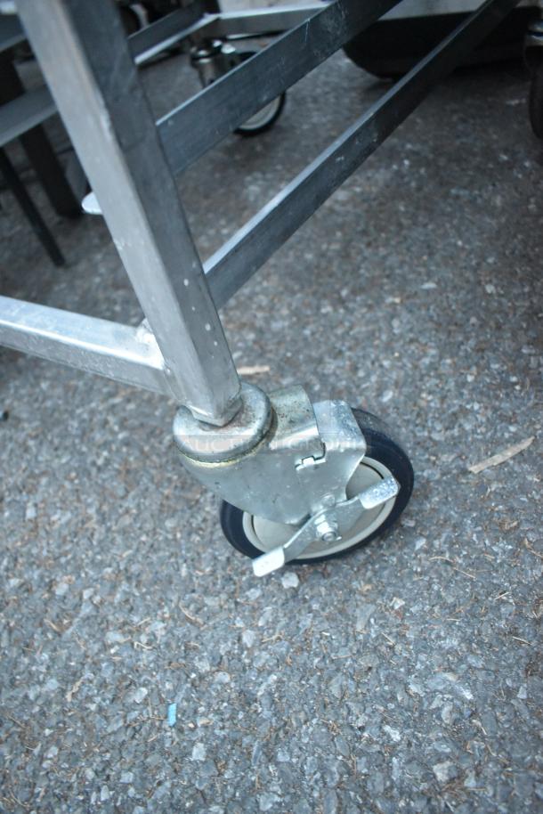 Metal portable pan rack with sturdy commercial casters, durable construction, ideal for kitchen use.