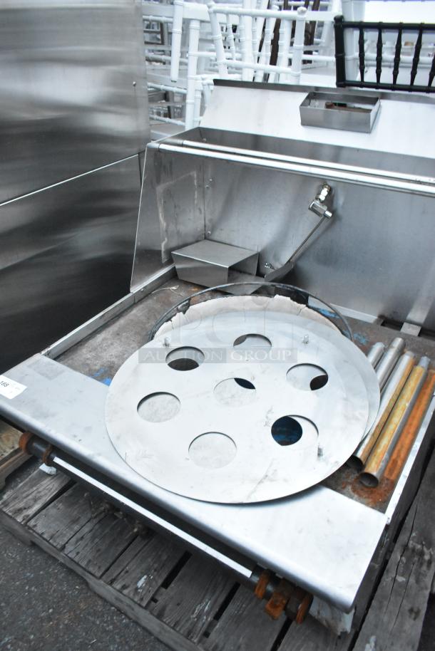 Stainless steel commercial gas-powered single burner wok range with circular burner cover and visible gas connection, in used condition.