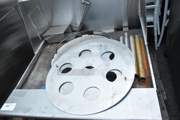 Stainless steel commercial gas-powered single burner wok range. Features circular burner plate, visible gas pipes, slightly worn condition. Auction tag with lot number 188½.