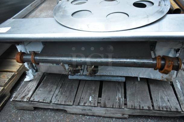 Stainless steel commercial gas-powered single burner wok range, features a round top and rusted gas connections, used condition.
