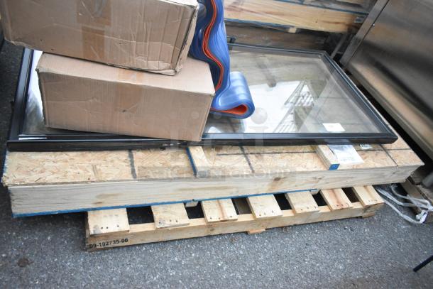 Two brand new scratch and dent doors on a pallet, framed with protective packaging.