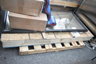Two brand new scratch and dent doors on a pallet, framed with protective packaging.