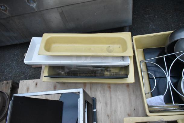 Three pallets of assorted items including a ladder, mop bucket, and metal baking pans. Items are stacked for auction.