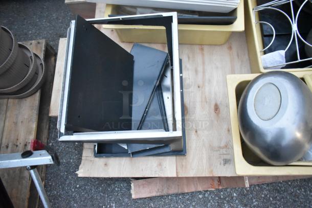 Pallets with ladder, mop bucket, metal baking pans; mixed items on wood. Various sizes and materials shown.