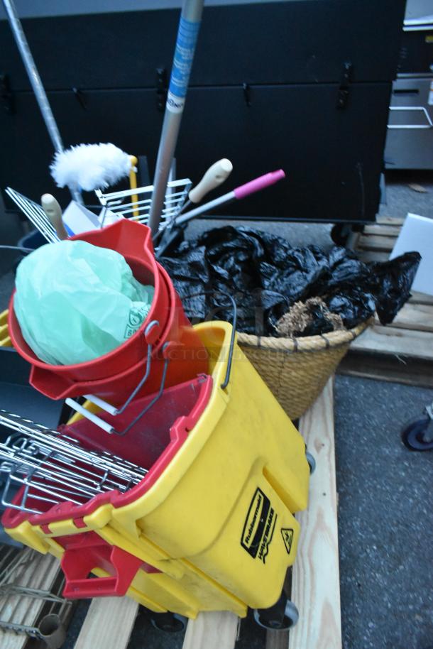 Three pallets with a mop bucket, ladder, metal pans, and cleaning tools. Rubbermaid label on yellow bucket. Mixed items auction.