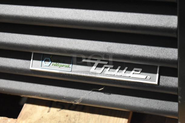 True GDM-72-HC metal commercial cooler. Features True logo, "natural refrigerant" label. 3-door merchandiser with coated racks.