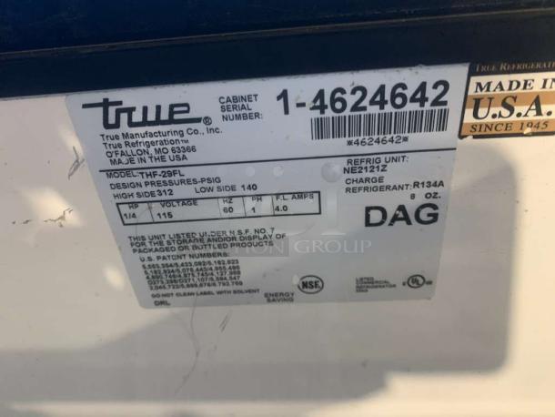 Label on True THF-29FL horizontal glass-top freezer showing model details, serial number, refrigerant type, and voltage.