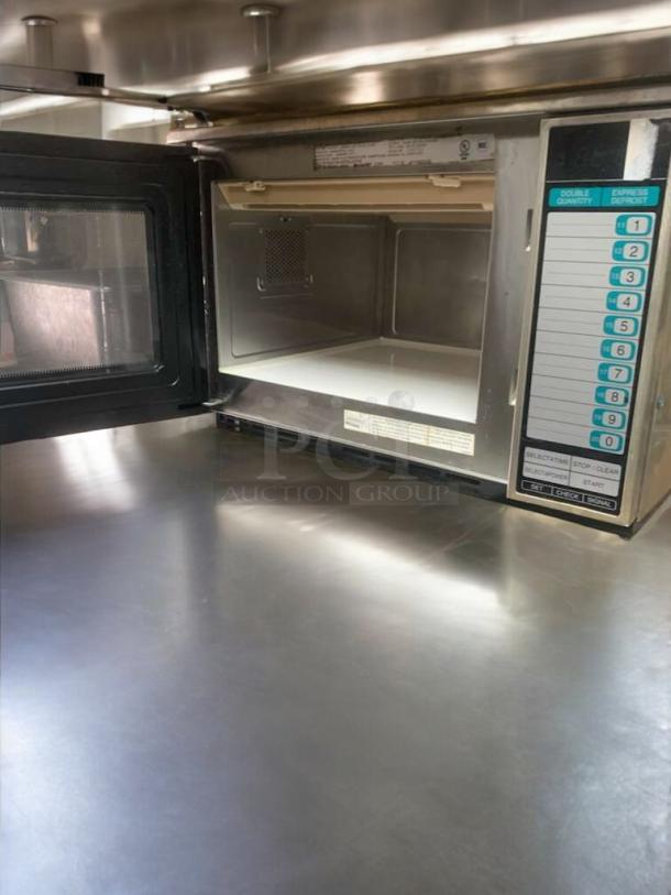 Sharp commercial microwave, heavy-duty model, open door view showing interior. Features touchpad controls, in prime condition.