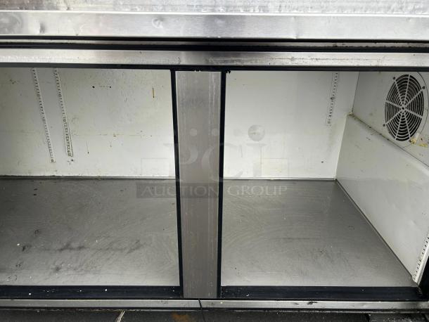 True TPP-93 3-door refrigerated pizza prep table, 93", tested and working. Interior view, stainless steel, used condition.