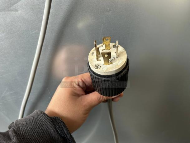 Hand holding a power plug against a two-door refrigerator model XDR640-F1A, tested and in excellent condition.