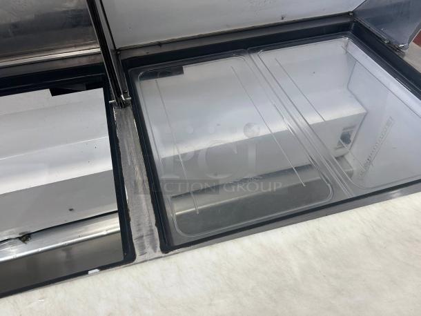 True TSSU-60-24M-B-ST-HC sandwich prep table in excellent condition, two-door design with clear lid, tested and working.