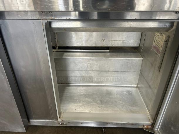 Continental SW60N24M 60" 2-door refrigerated prep table interior, excellent condition, visible label, clean stainless steel.