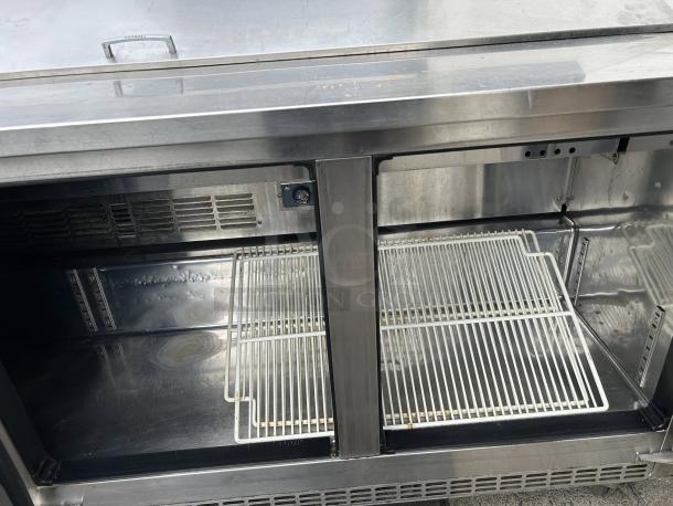 Everest EPBNR3 71" stainless steel refrigerated prep table with three solid doors; interior shelving, tested, working condition.
