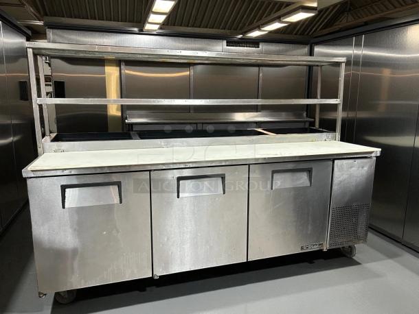 True TPP-93 93" 3-door refrigerated pizza prep table with overshelf. Stainless steel, tested, working, in good condition.