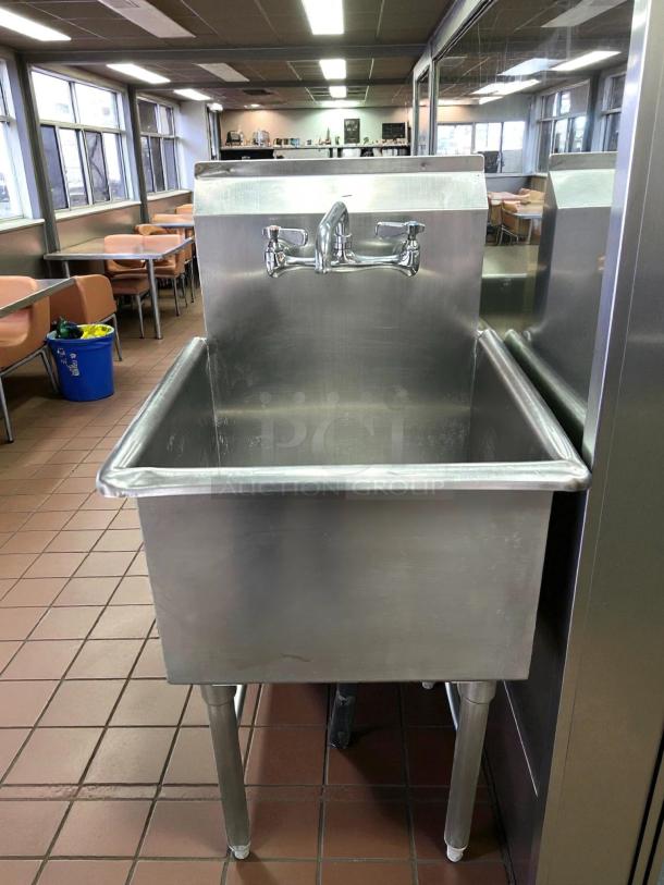 All stainless steel single compartment sink in great condition, featuring a wall-mounted faucet, ideal for commercial use.