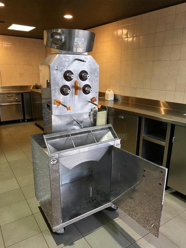 Citrocasa 8000 SB-ATS citrus juicer, stainless steel, \"AS IS,\" visible wear, open lower compartment, commercial kitchen setting.