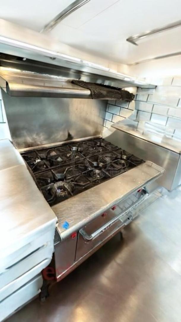 American Range 6-burner gas range with standard oven and high back shelf. Outstanding condition, fully tested, stainless steel finish.