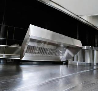 Commercial stainless steel exhaust hood in pristine condition, fully tested and working, with sleek design and robust construction.