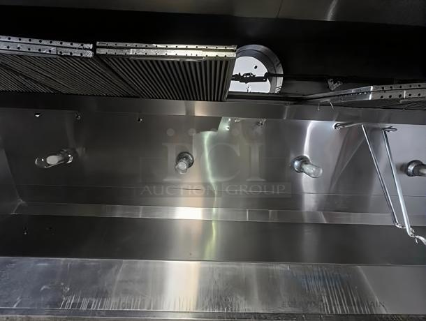 Pristine commercial stainless steel exhaust hood, fully tested and working, featuring sleek finish and seamless vent design.