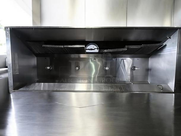 Pristine stainless steel commercial exhaust hood, fully tested, working condition, with integrated filters and lighting.