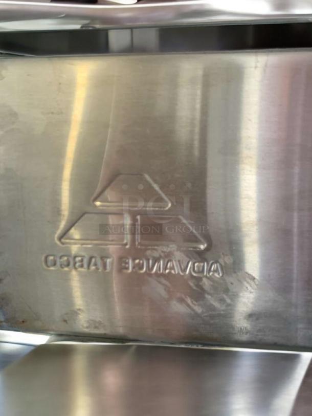 Embossed logo on shiny stainless steel surface of Advance Tabco T9-3-54-PX sink.