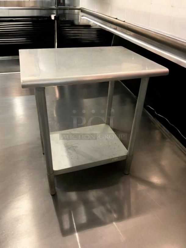 Stainless steel prep table in prime condition, featuring a sturdy workspace and lower shelf; fully tested and ready for use.