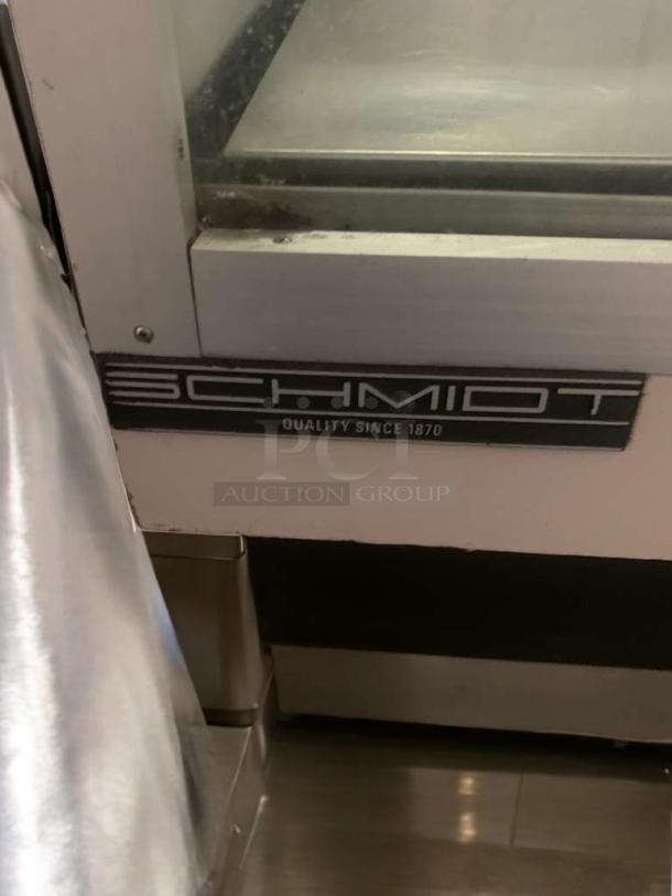 Schmidt curved glass refrigerated display case, immaculate condition, bakery/deli use, 115V, "Quality Since 1870" label.