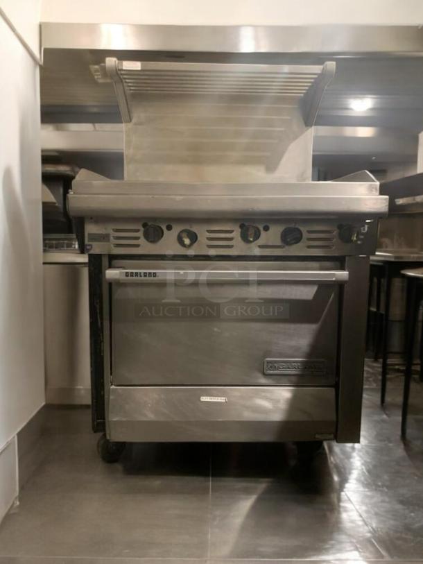 Garland 36" gas griddle with oven base, cabinet, and overhead shelf. Heavy-duty, commercial-grade, elite condition.