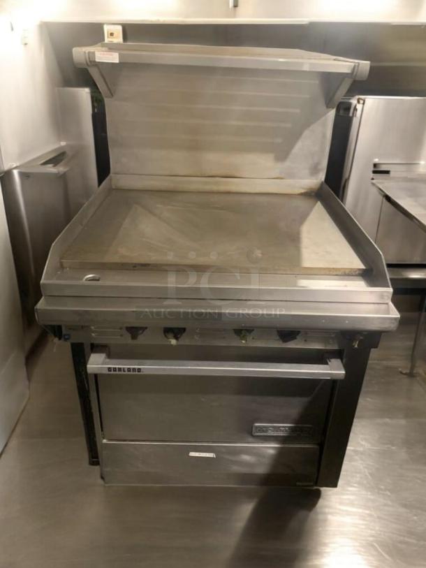 Garland 36" Heavy-Duty Gas Griddle with oven base, cabinet, and overhead shelf, excellent condition, commercial use.