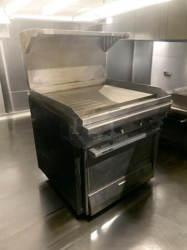 Garland 36" heavy-duty gas griddle with cabinet base and overhead shelf, elite condition, fully tested and working.