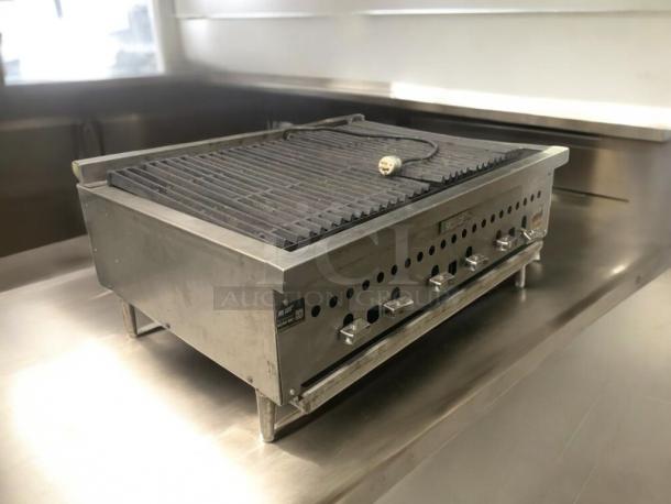 Commercial stainless steel countertop charbroiler gas grill, superb condition, fully tested, with control knobs and drip tray.