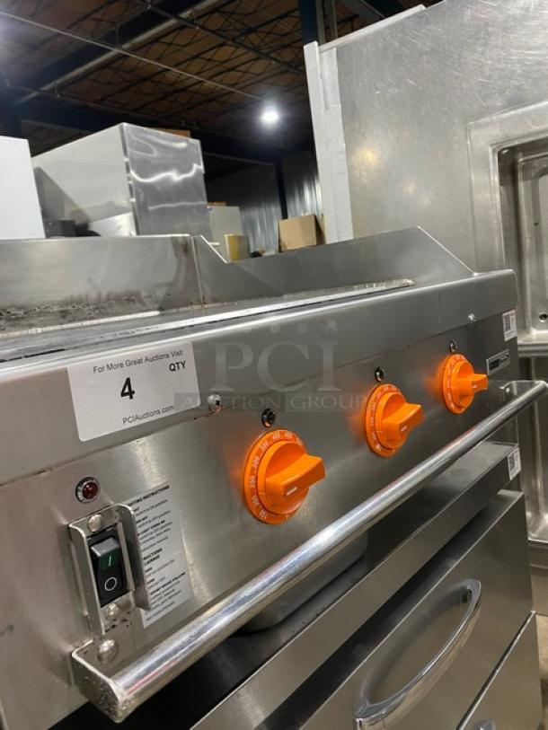 Woodstone 36" flat griddle, model WSGPL3636CT01NG. Stainless steel, natural gas, orange knobs, back and side splashes. Serial GP3B01AUG2212200.