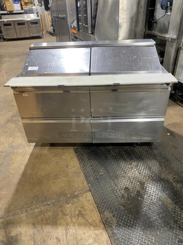 Stainless steel Welbilt/Delfield commercial refrigerated prep table, model D4460NP-24M, with four drawers and cutting board.
