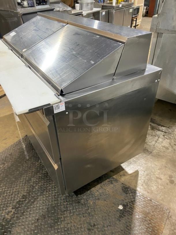 Welbilt/Delfield D4460NP-24M commercial stainless steel refrigerated prep table with 4 drawers, cutting board, on casters.