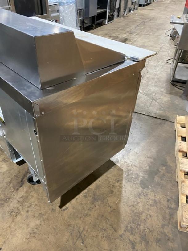 Welbilt/Delfield refrigerated prep table, model D4460NP-24M. Stainless steel, four refrigerated drawers, commercial casters.