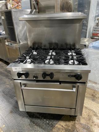 Sunfire X366R 6 burner stainless steel range/oven combo with raised backsplash and overhead salamander shelf on casters.
