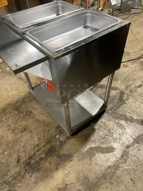 Omcan Model FZ06B1 electric 2-bay steam table, stainless steel, with underneath storage, shown on warehouse floor.