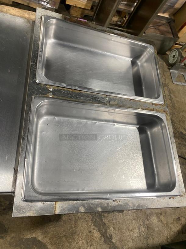 Stainless steel Omcan 2-bay commercial steam table, model FZ06B1, with underneath storage. Serial: 690207445119, 120V. Excellent condition.