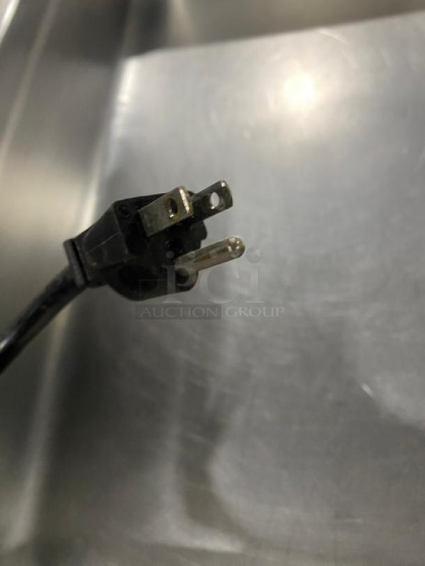 Close-up view of an Omcan commercial steam table power cord plug, model FZ06B1, 120V. Stainless steel background.