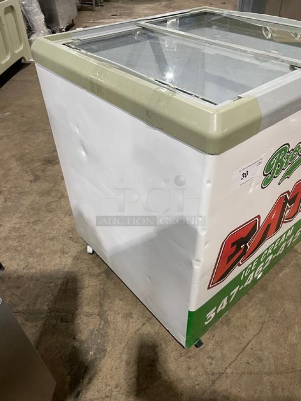 Commercial reach down chest freezer merchandiser with 2 sliding view-through doors, 110V. Features promotional signage.