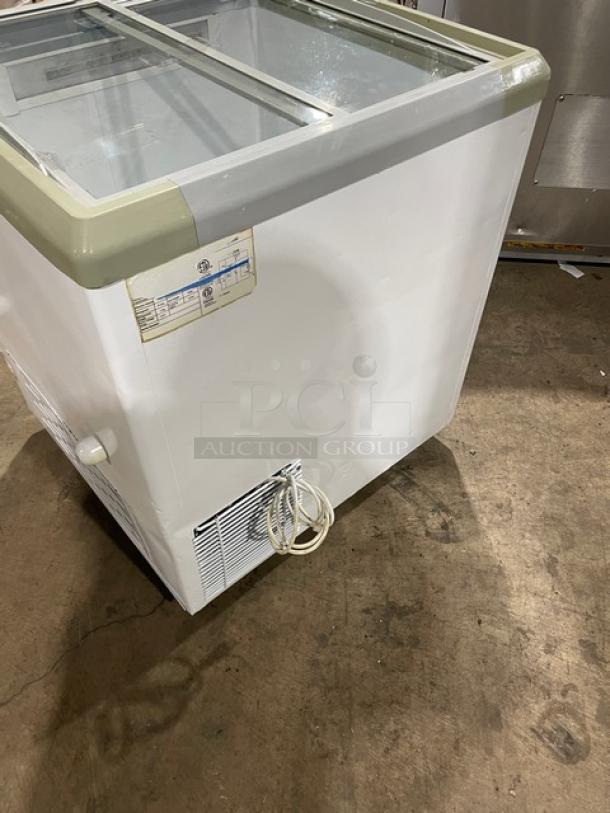 Commercial chest freezer merchandiser with two sliding glass doors, 110V. Features visible label and power cord, good condition.